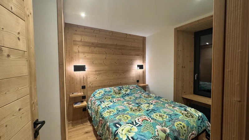 Deux appliques de chevet sur une tête de lit en bois.