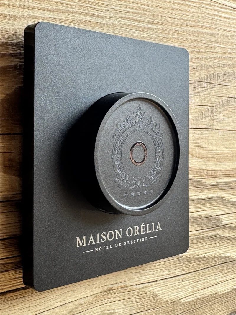 Vue rapprochée en perspective de la commande ronde gravée et du texte Maison Orélia.