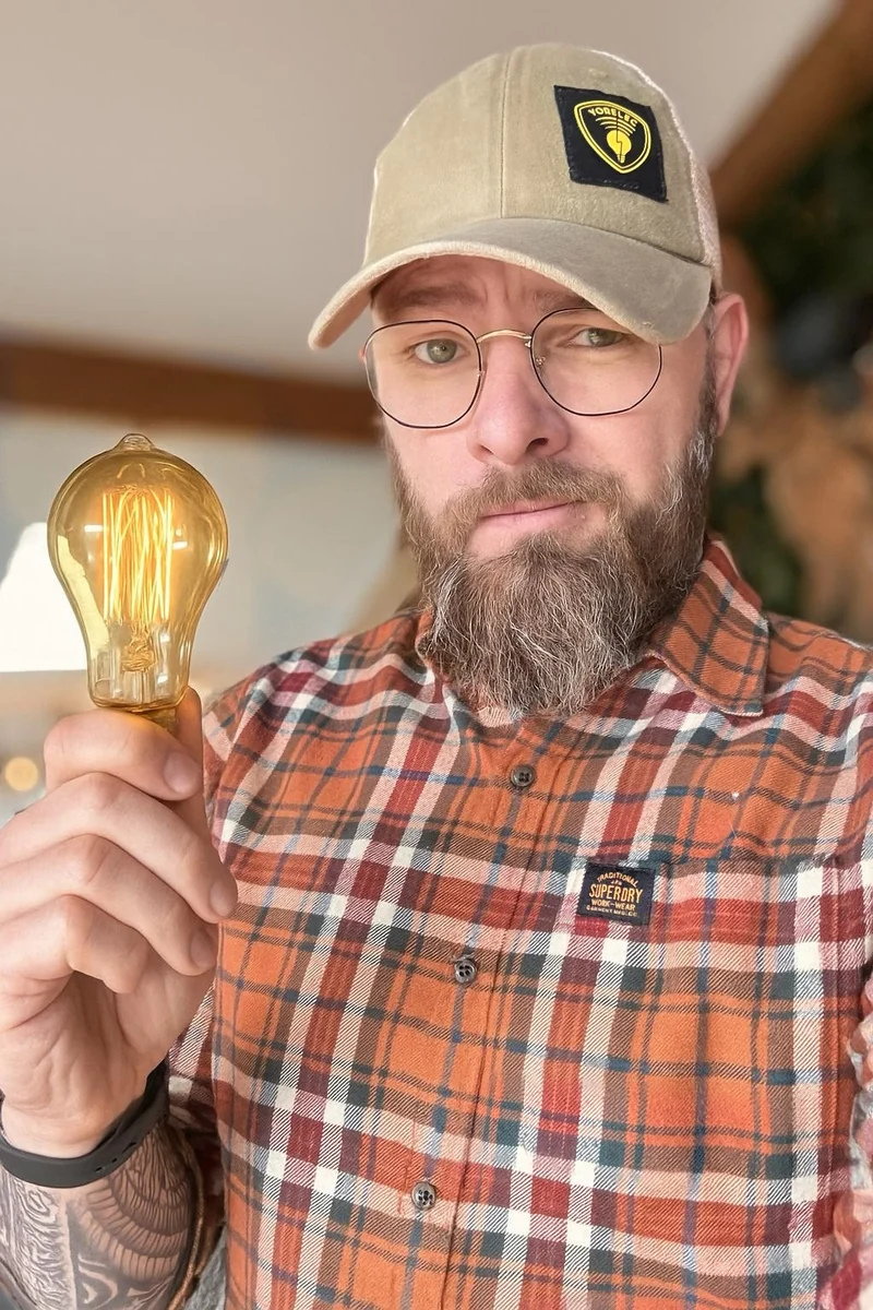 Guillaume Leroy, électricien Yorelec, tenant une ampoule allumée.