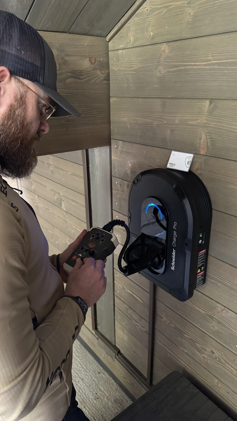Je contrôle une borne Schneider Charge Pro installée sur le bardage bois du chalet.