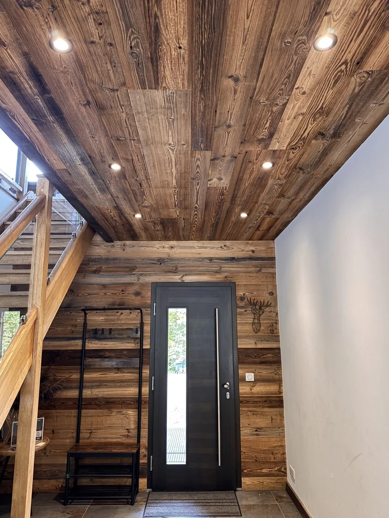 Spots intégrés au plafond en bois d’une entrée de chalet.
